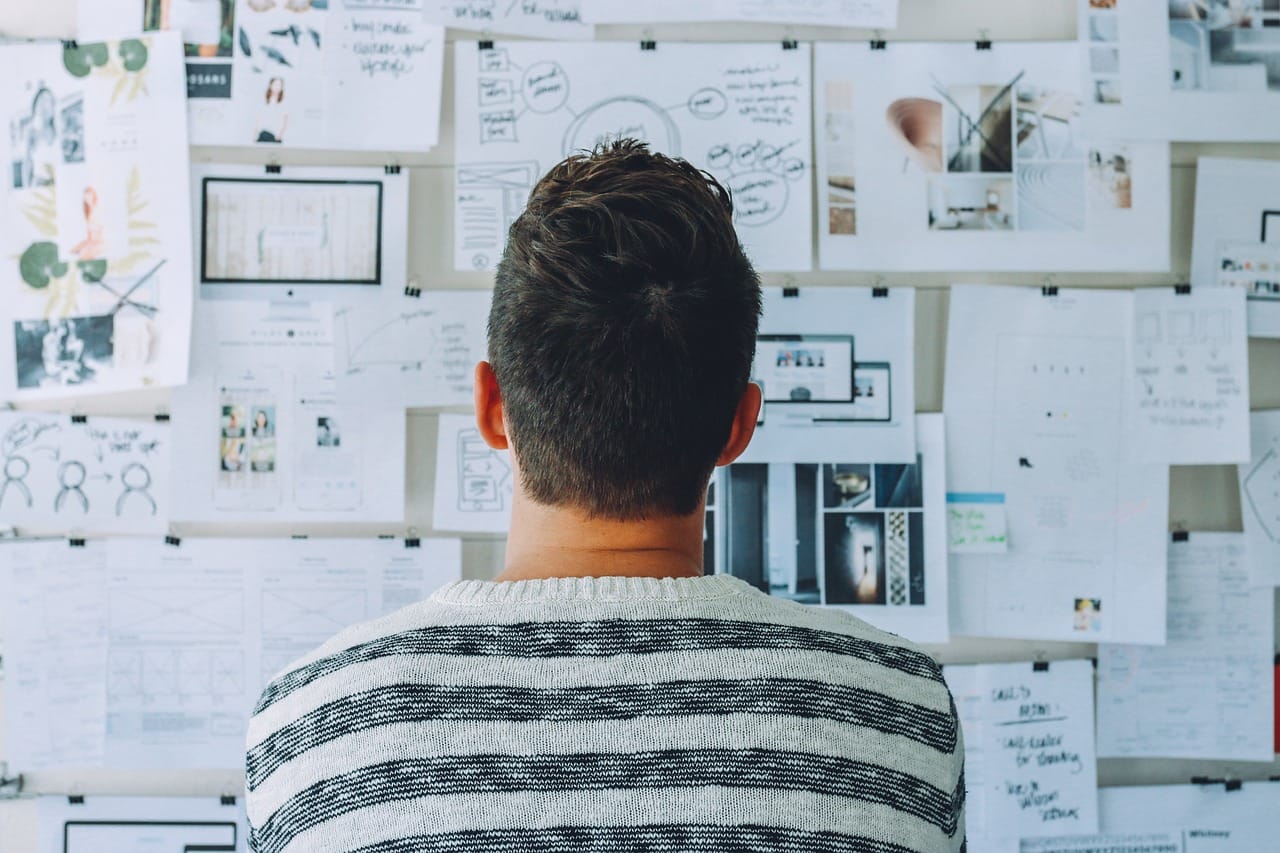 image showing a person looking a monthly plan pasted on the wall