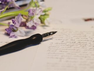 चित्र में सुलेख हस्तलेखन और फूलों से सजा हुआ डायरी पृष्ठ दिखाया गया है