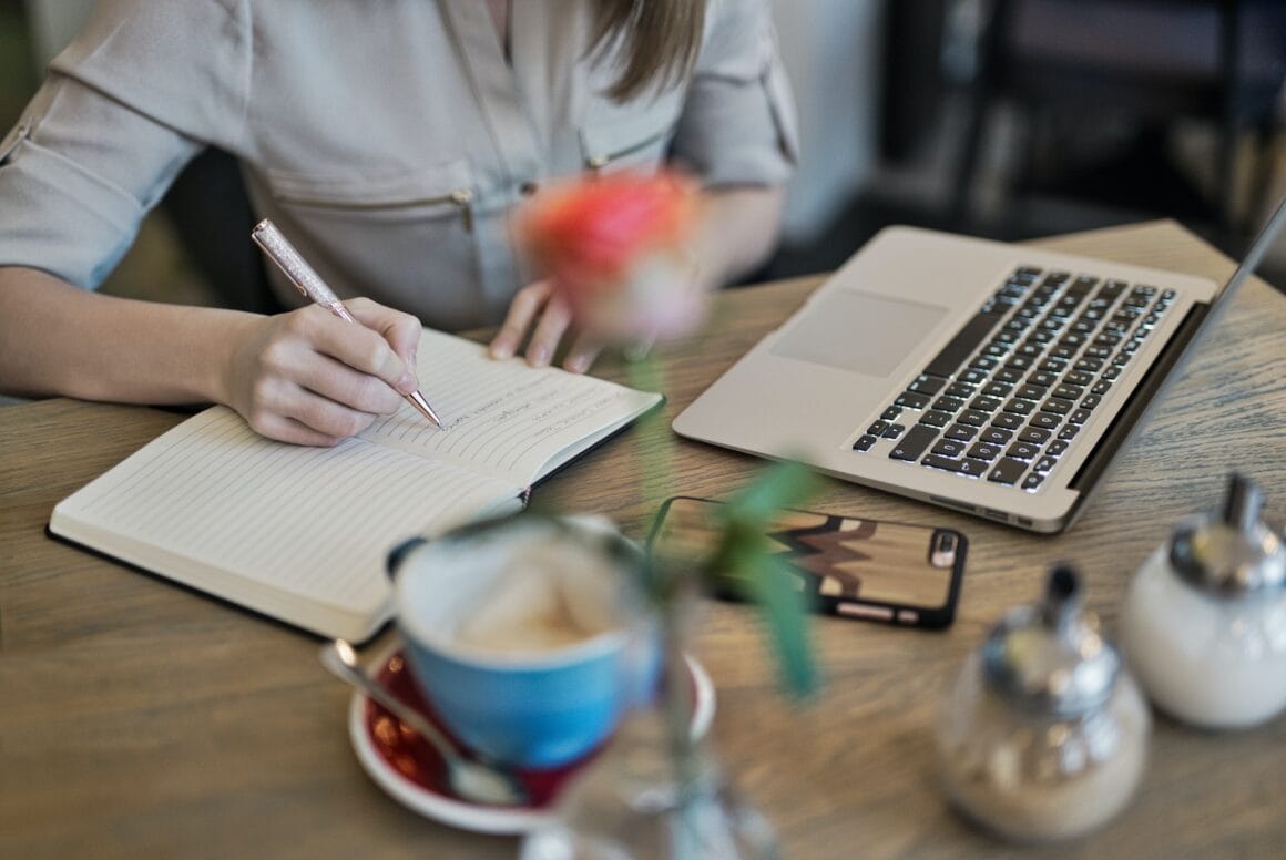 Person Writing Novel On A Notebook