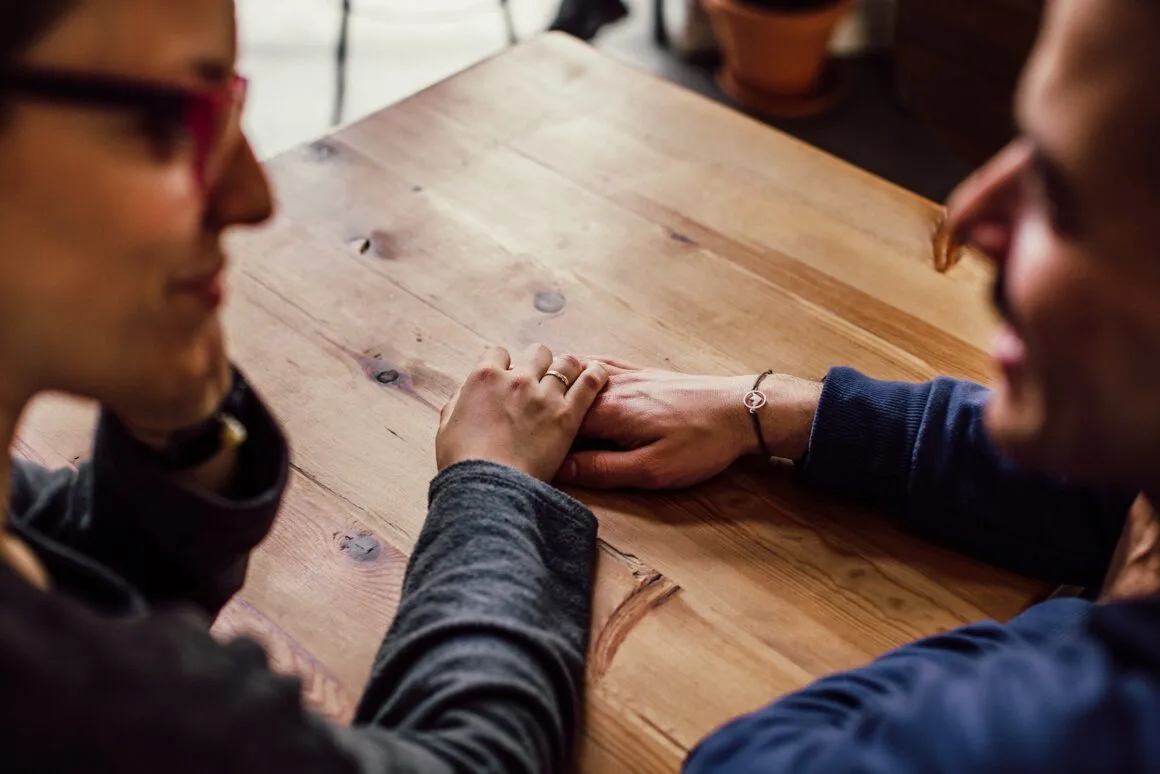 husband and wife Sitting Together in Front of Table Talking